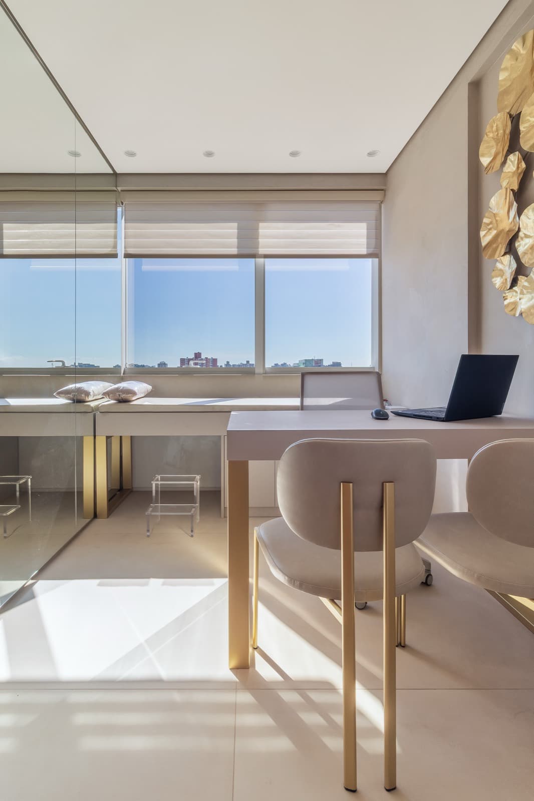 A finished consulting room, bright, with leather chairs on brass legs by the window